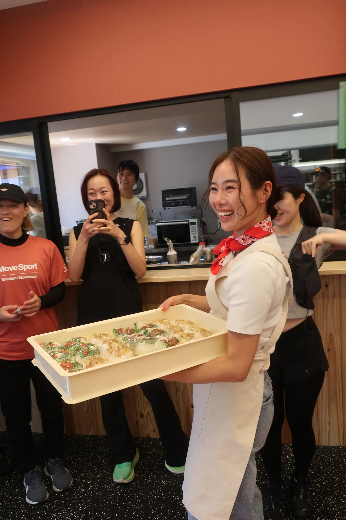 ラン後の食体験として商品を手渡すコラボ店舗のスタッフ